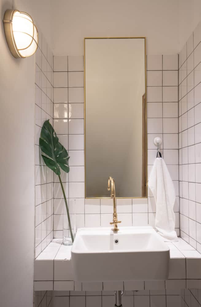 white tile powder room with gold accets 
