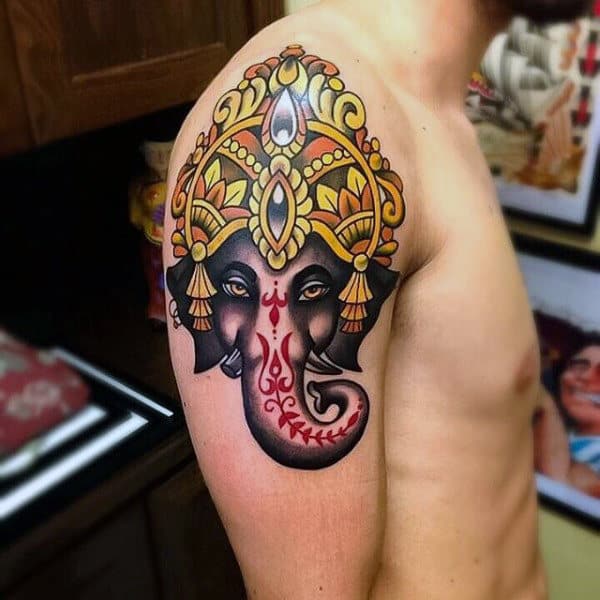 Colorful Ganesh tattoo on a man's upper arm showcasing intricate details and symbols