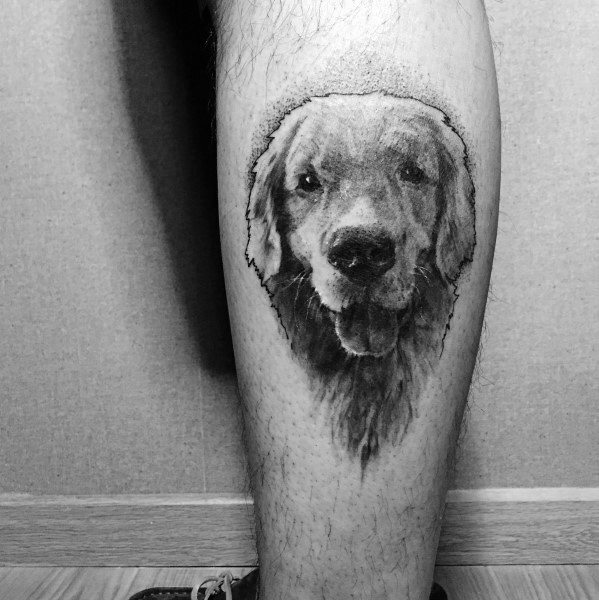 Realistic black and grey Golden Retriever tattoo on the leg, featuring detailed fur shading and expressive eyes for a lifelike portrait.