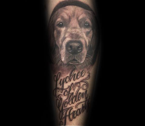 Realistic Golden Retriever tattoo on the forearm, featuring detailed shading, lifelike eyes, and elegant script text for a sentimental tribute.