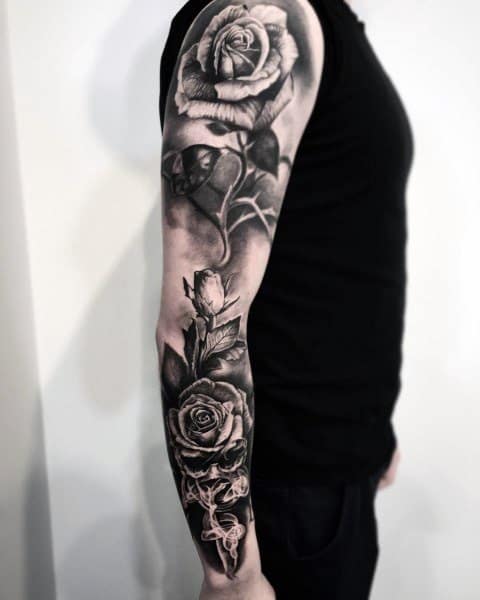 A stunning black and gray sleeve tattoo beautifully adorned with intricate roses entwined around a heart