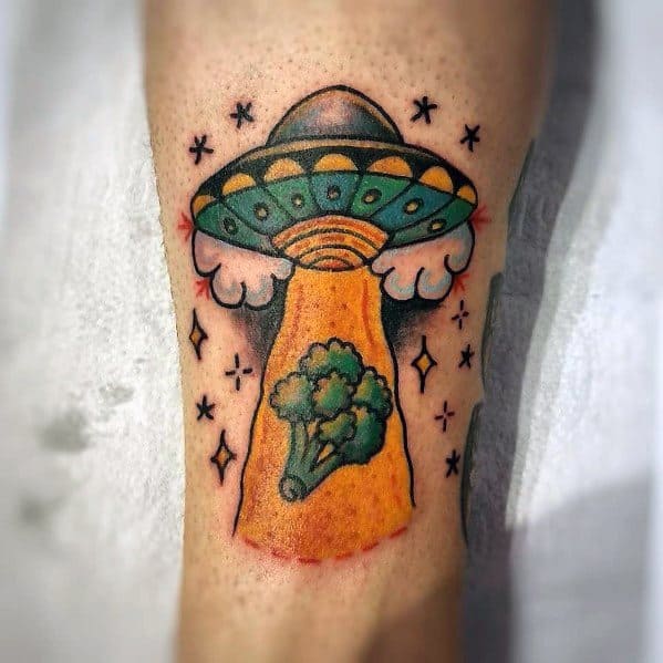 Colorful UFO and broccoli tattoo, featuring bold outlines and vibrant shading, depicting a playful alien abduction theme with a creative twist.