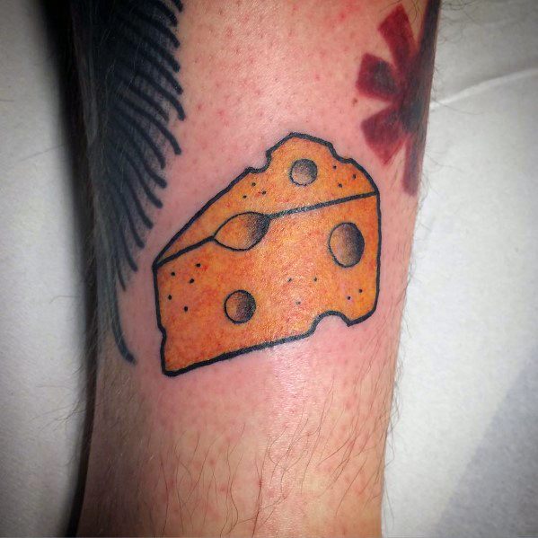 Simple cheese wedge tattoo with bold black outlines and bright yellow-orange shading, featuring a classic Swiss cheese design on the forearm.