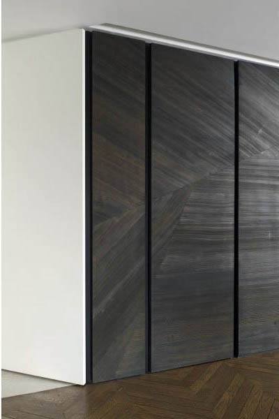 Minimalist dark wood closet doors complement a white wall