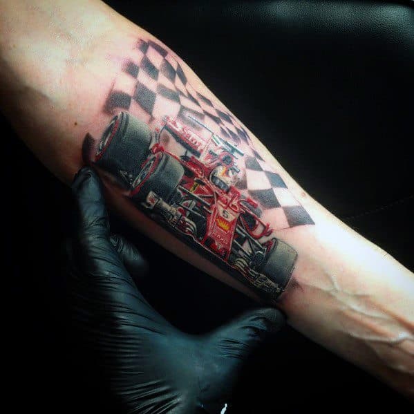 Realistic Ferrari Formula 1 tattoo with checkered flag on man's forearm, showcasing dedication to racing and competitive spirit.