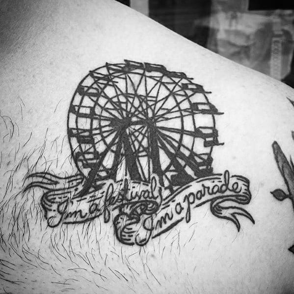 Black ink Ferris wheel tattoo with bold linework, featuring a flowing banner that reads "I'm a festival, I'm a parade," adding a festive touch.