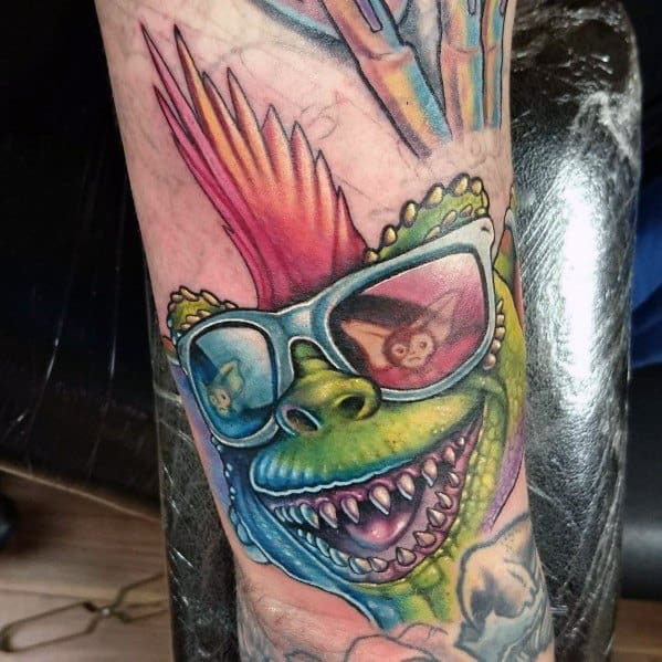 Colorful Gremlin tattoo with a mohawk, reflective sunglasses showing Gizmo, and sharp teeth, blending vibrant and bold details.