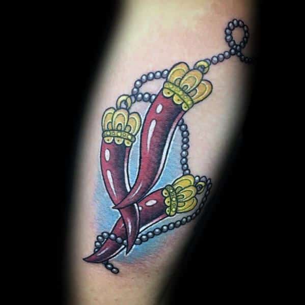 Triple Italian horn tattoo with golden crowns and beaded chain, symbolizing protection, strength, and cultural heritage.