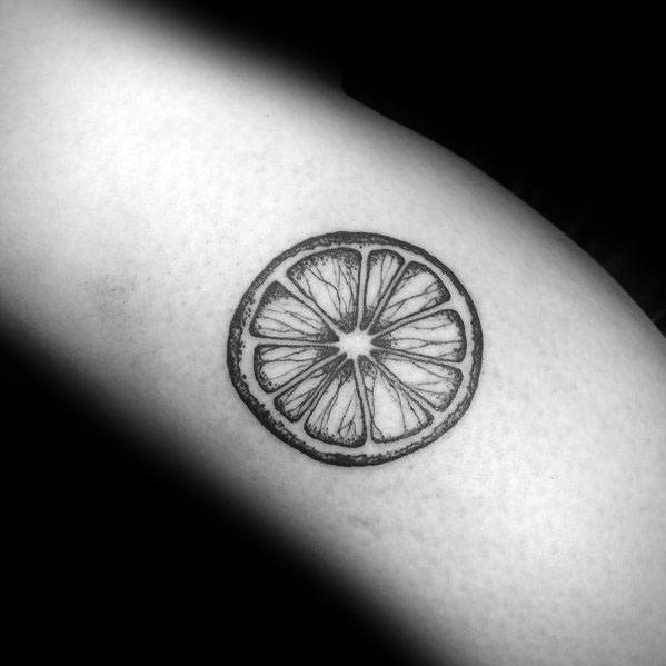 Minimalist black ink lime slice tattoo with fine line details, creating a clean and stylish citrus-inspired design.