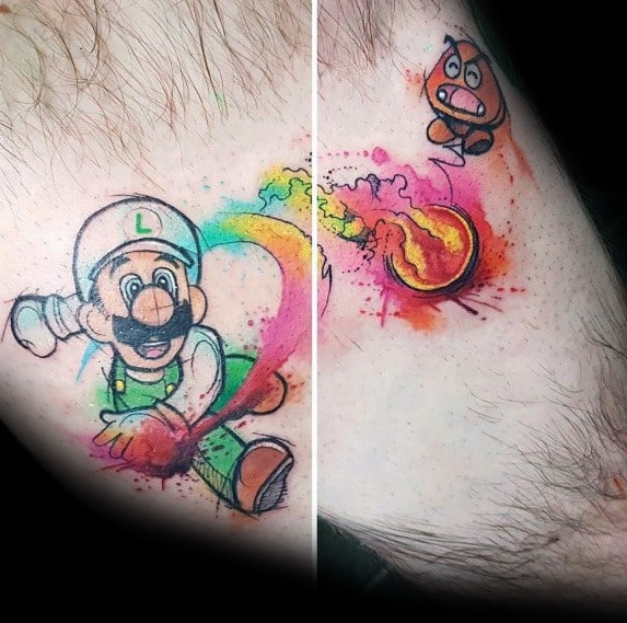 Watercolor-style tattoo of Luigi throwing a fireball at a Goomba, with splashes of vibrant colors and dynamic motion effects.