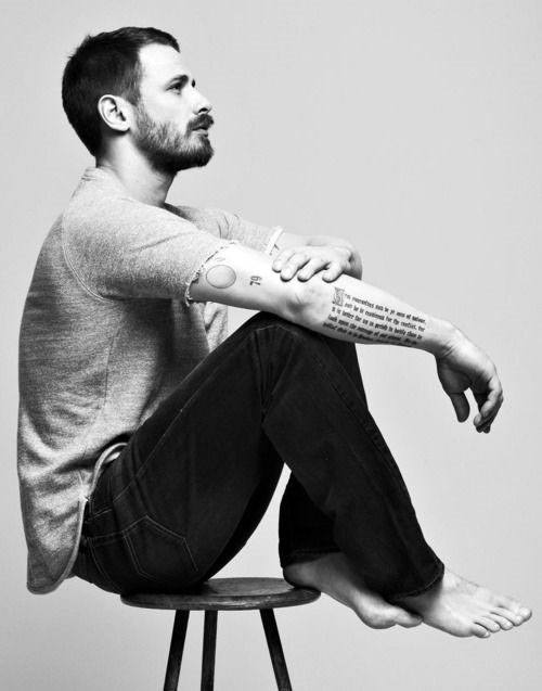 Forearm tattoo with a long, vertical script text