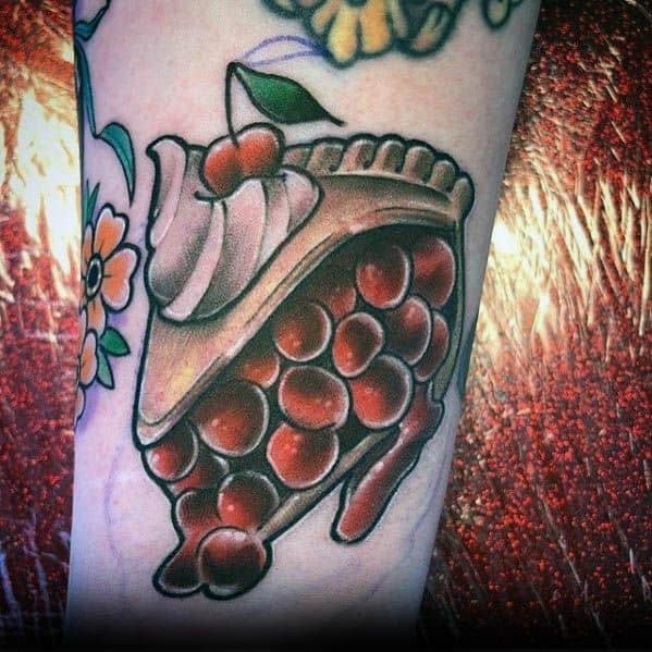 Cherry pie tattoo with a dripping filling, topped with whipped cream and a cherry, blending realism and traditional tattoo artistry