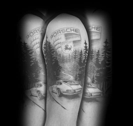 Shaded Porsche tattoo featuring a classic car driving through a forest with emblem background.