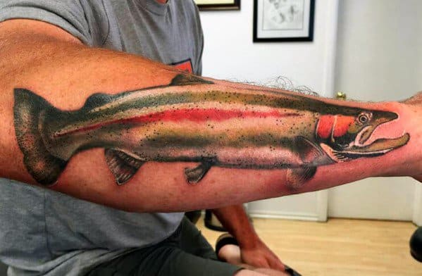 Realistic salmon tattoo stretching across the forearm, showcasing detailed shading and vibrant red accents for a bold and lifelike design.