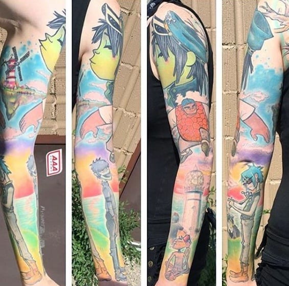 Full-sleeve color tattoo featuring Gorillaz characters in various scenes, set against a vibrant rainbow sky and dreamy background elements.
