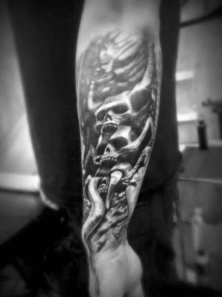 Black and grey forearm tattoo featuring stacked skulls, skeletal structures, and eerie shading for a dark and haunting gothic design.