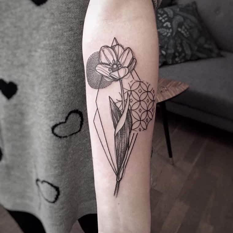 A geometric tulip tattoo on the forearm, combining the flower with sharp lines, circles, and intricate shapes for a modern, artistic design.