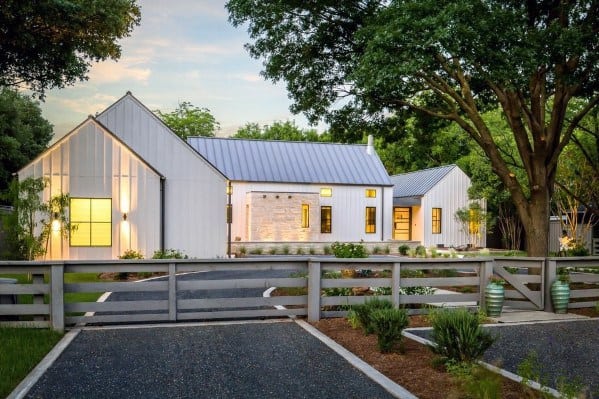 Gravel driveway with clean white borders leading to a modern farmhouse-style home and garden.