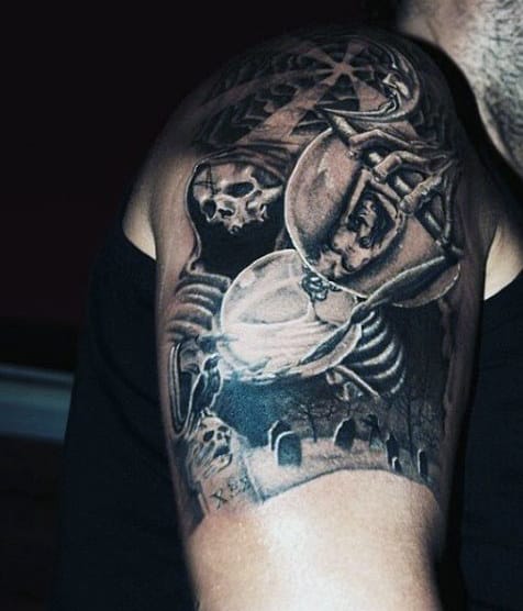 Detailed dark-themed tattoo of skeletons in a graveyard on upper arm