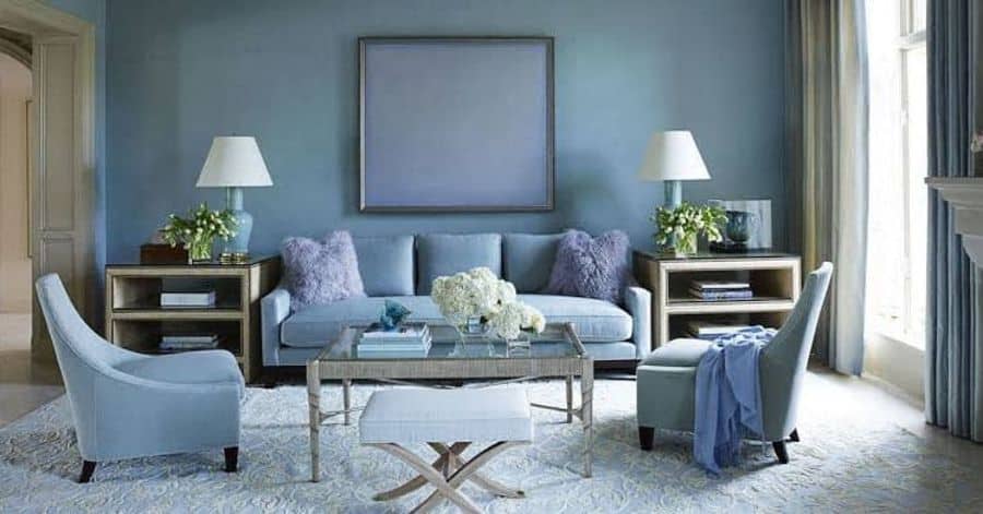 Elegant living room with soft blue furniture, matching walls, and symmetrical decor.