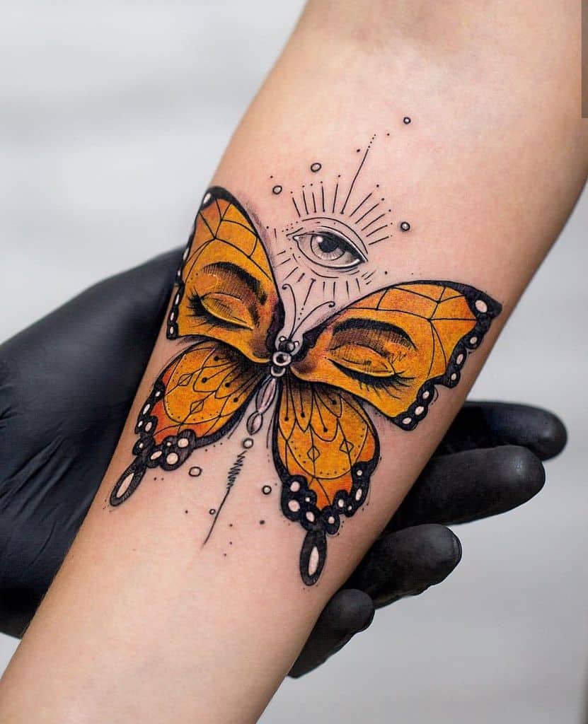 Tattoo of a butterfly with human eyes on its wings and a third eye above, detailed with fine lines and shading on the forearm.