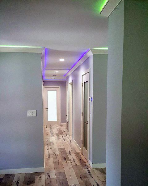 Modern hallway with colorful green and purple LED crown molding lighting, creating a dynamic atmosphere
