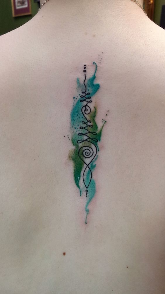 Unalome tattoo with green and blue watercolor accents on the spine, symbolizing spiritual growth, balance, and the journey toward enlightenment.