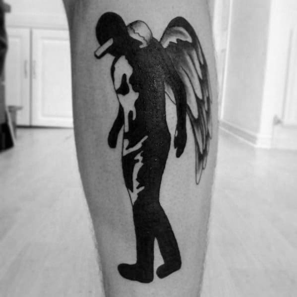 Black and white tattoo of a winged figure in a cap, inspired by Green Day’s *21st Century Breakdown* angel imagery.