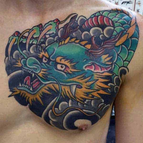 Bold upper chest tattoo showcasing a fierce green Japanese dragon with intricate scales and dynamic cloud designs