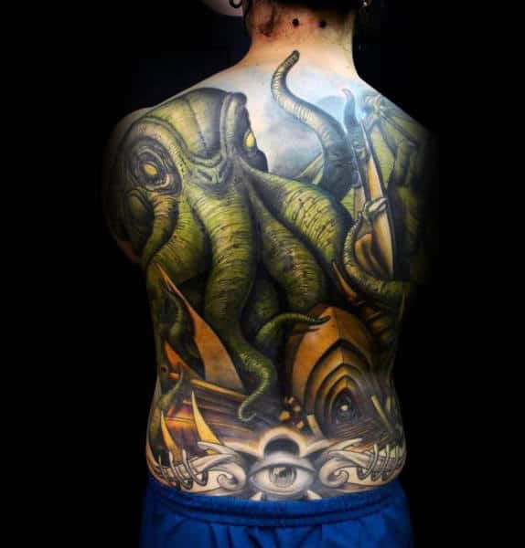 Back tattoo of a green octopus entwined with a ship in front of a mysterious eye