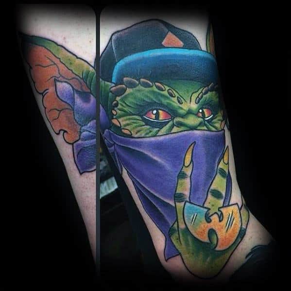 Gremlin tattoo with a street-style twist, featuring a cap, bandana mask, and a peace sign, blending urban and fantasy elements.