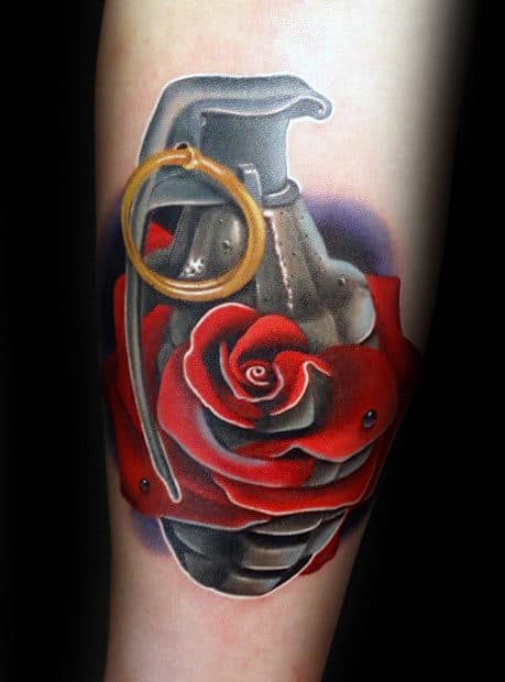 Tattoo of a hand grenade entwined with a red rose on an arm