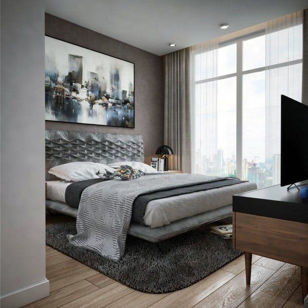 Modern bedroom with large window, abstract art, and a grey color scheme featuring a bed, lamp, and TV