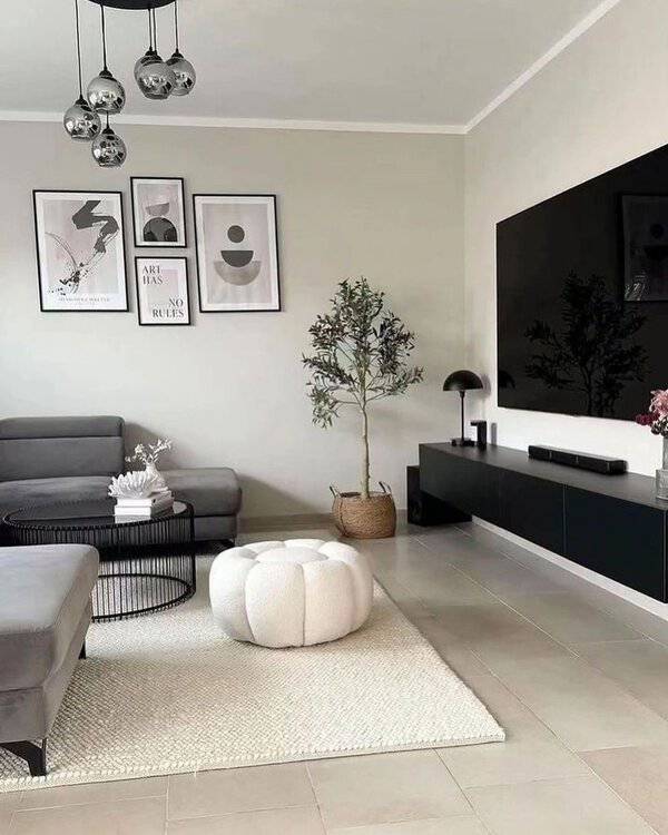 Small grey and white living room with a sectional sofa, wall-mounted TV, and modern decor.