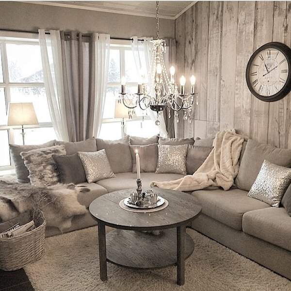 Cozy grey and white living room with rustic wood accents, a chandelier, and soft textures.