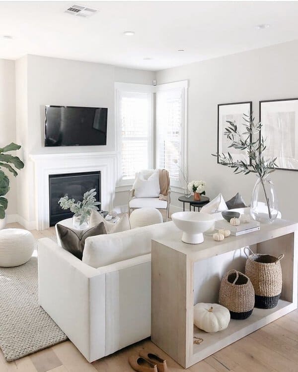 Bright grey and white living room with a cozy fireplace, modern decor, and smart storage solutions.