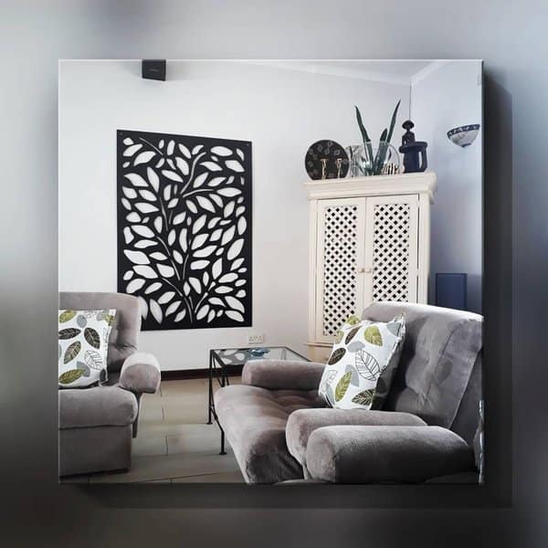 Grey and white living room with plush seating, leaf-patterned pillows, and artistic wall decor.