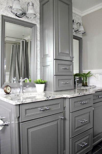 Traditional grey bathroom vanity with intricate cabinetry, marble countertop, and chrome fixtures.