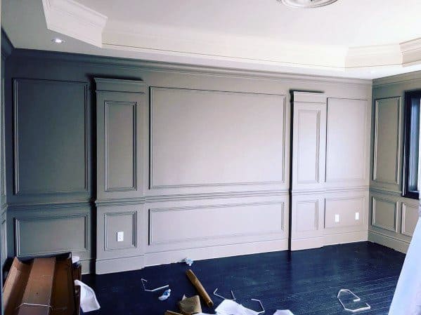 Elegant room with gray chair rail molding, paneled walls, and dark wood flooring for a classic and refined aesthetic