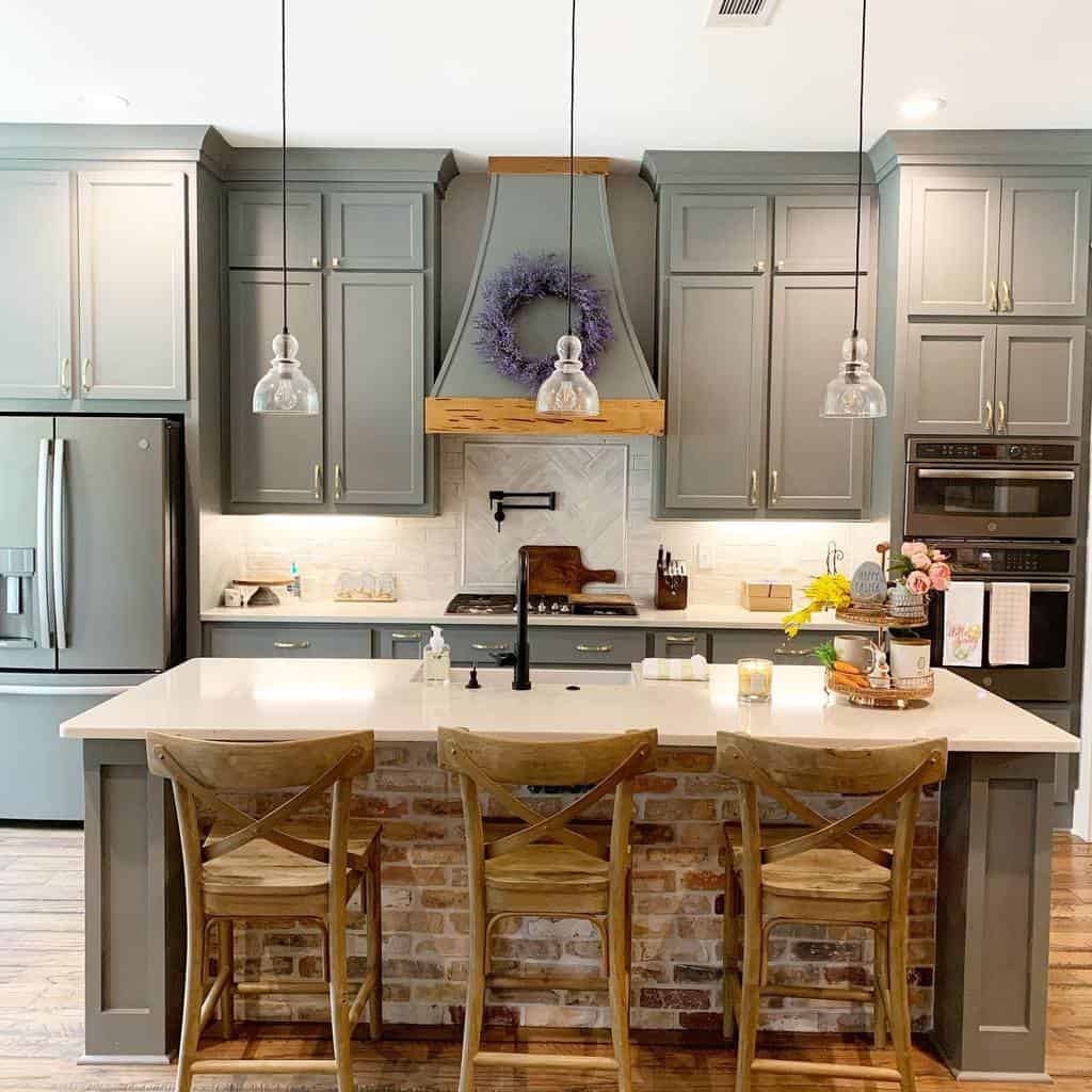 large grey farmhouse kitchen brick island with granite countertop wood chairs 