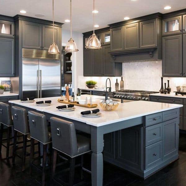 gray kitchen cabinets with white countertops four chairs and track pendant lighting 
