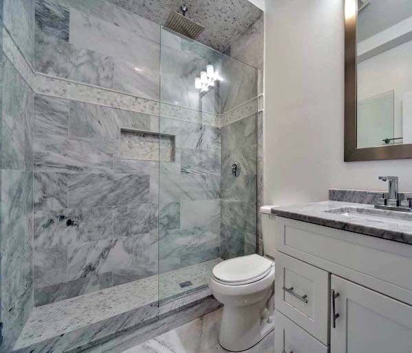 White modern bathroom with marble shower, glass door, toilet, and vanity with mirror
