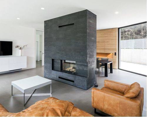 Minimalist living space featuring a modern grey concrete fireplace with a dual-sided view.