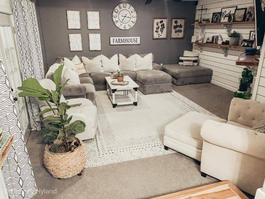 gray modern farmhouse living room sectional sofa shiplap wall wood wall shelves carpet