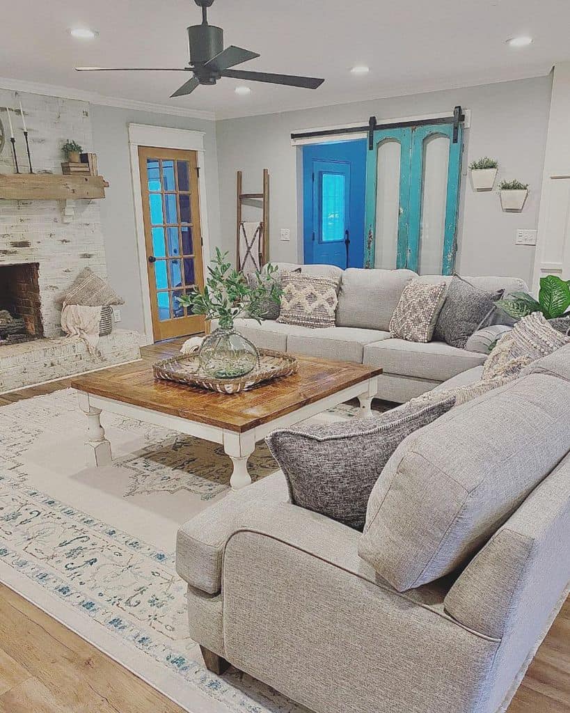 farmhouse living room brick fireplace gray sofa blue sliding barn door