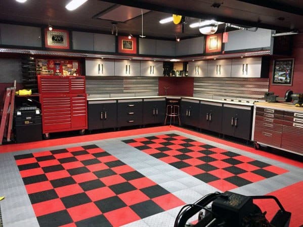 Garage with black and red checkered floor, custom cabinets, tool storage, and bright lighting.