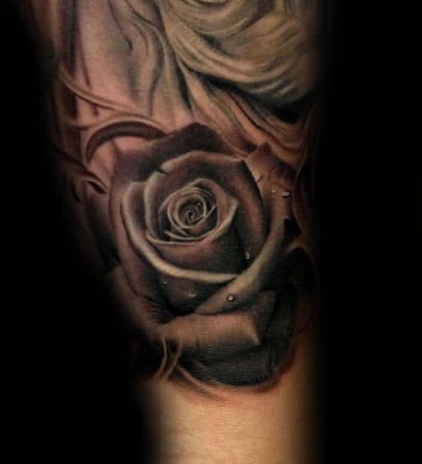 Black and gray tattoo of a rose with water droplets