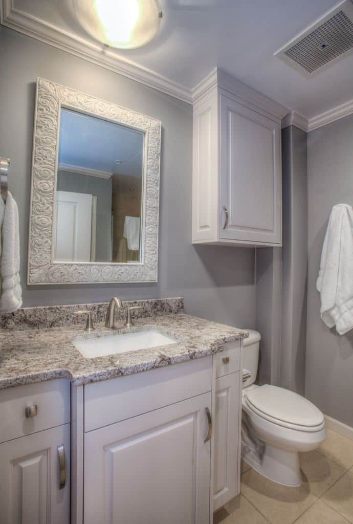 elegant gray bathroom with white vanity and cabinets 