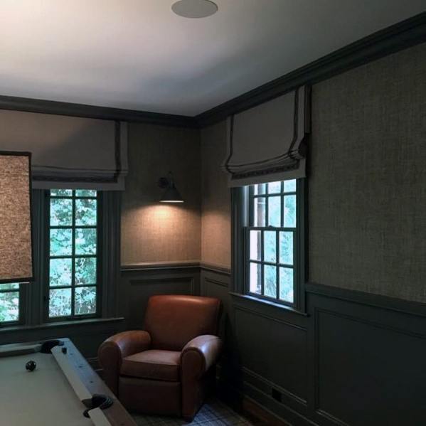 Cozy billiard room with gray walls, leather armchair, and soft natural light from windows.