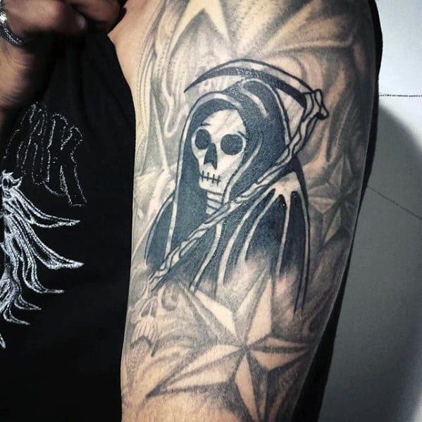 Blast Over grim reaper tattoo on upper arm, featuring a hooded figure and scythe